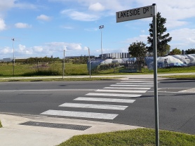 Use the pedestrian crossing to cross Lakeside Drive just before the roundabout at DFO